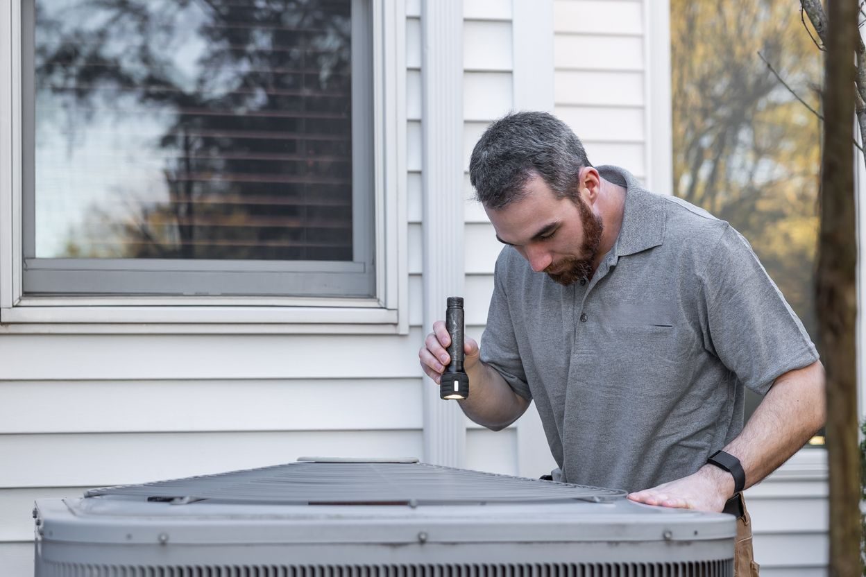 Technician servicing an outdoor air conditioning unit