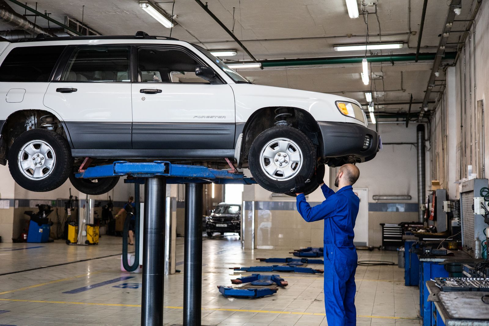 Mechanic working under a car in a repair shop