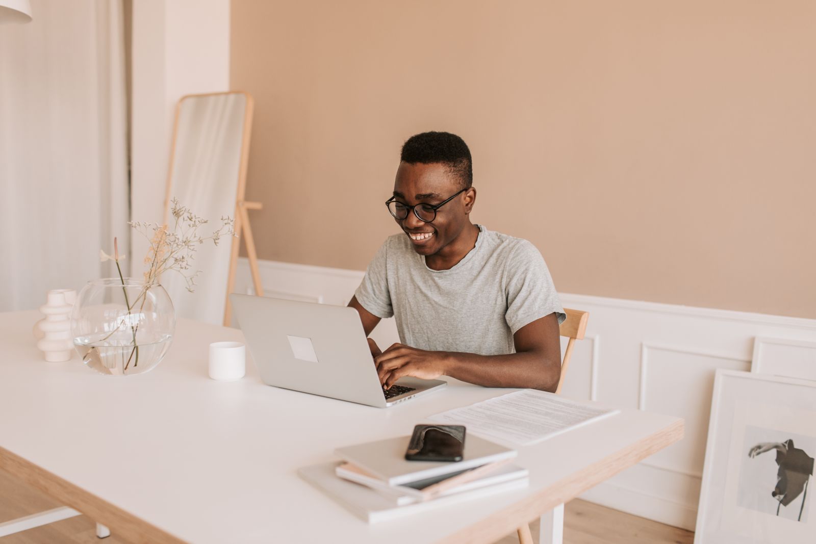 Smiling man reviewing his finances on a laptop at home